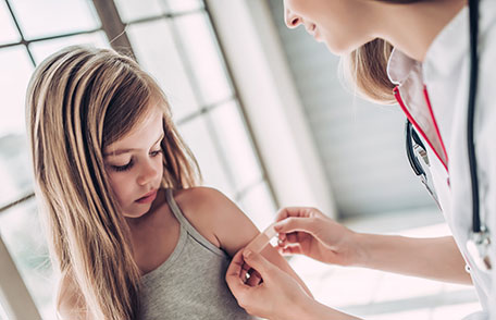 Young girl getting a band-aid after receiving her flu vaccination
